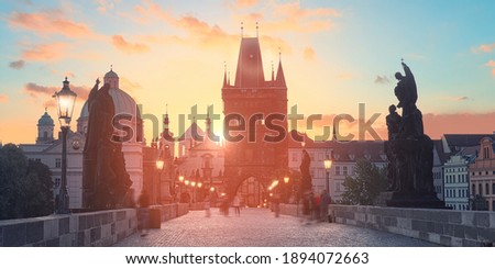 Charles Bridge at dawn: silhouettes of Old Bridge Tower, churches and spires of Old Prague on a sunrise, panoramic image.