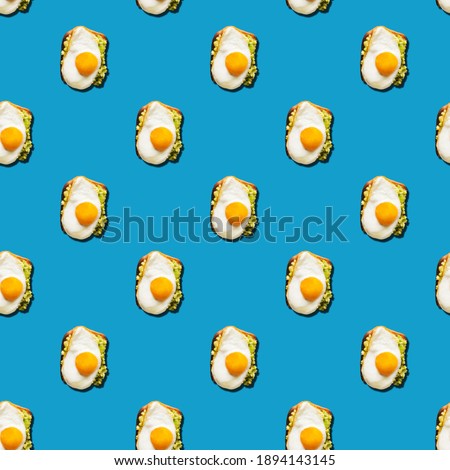 Seamless pattern of sandwich with fried eggs on blue background