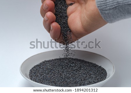 poppy seeds falling from a hand