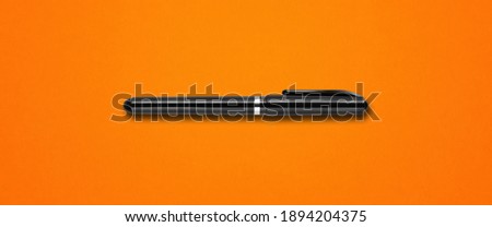 Black felt pen isolated on orange banner background Royalty-Free Stock Photo #1894204375