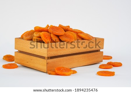 Naturally dried apricot.  Sun dried fruits in wooden box. Product for sale. Sun-dried fruits isolated on white. Copy space.