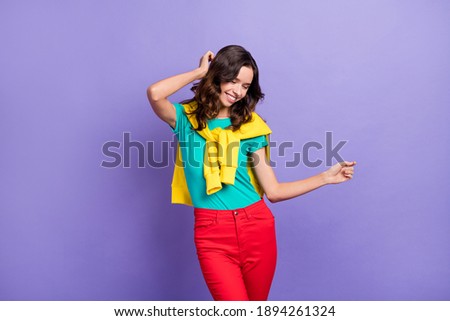 Portrait of attractive cheerful wavy-haired girl dancing enjoying free time isolated over violet pastel color background