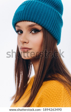 Close up portrait of beauty young woman in hat and yellow jacket isolated on white background. Fashionable model in studio