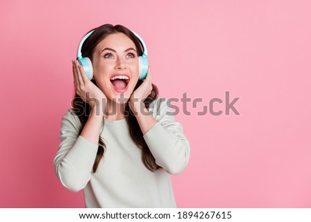 Photo of nice wavy hairdo lady look empty space open mouth arms touch earphones isolated on pink color background