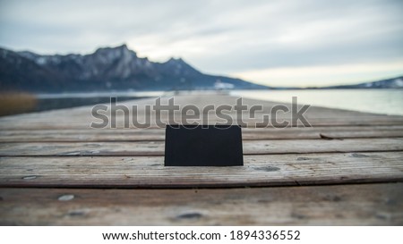 blank business card for your text and logo on the background of the Austrian mountain lake. black blank business card. black sheet of cardboard free standing