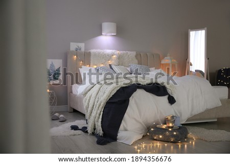 Cozy bedroom interior with warm blanket and cushions