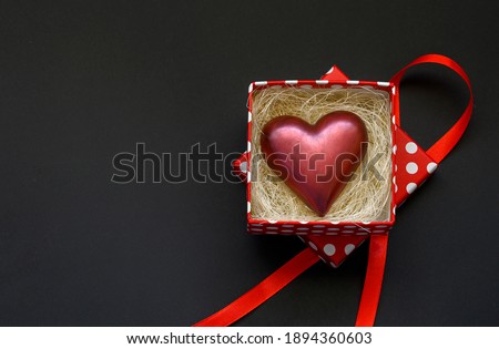 Chocolate heart in a beautiful box on a black background. Valentine's day gift concept, card concept.