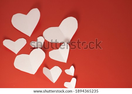 white paper hearts on red isolated background. valentine's day cards with copy space