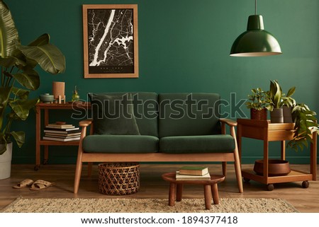 Stylish living room in house with modern retro interior design, velvet sofa, carpet on floor, brown wooden furniture, plants, poster mock up map, book, lamp and perosnal accessories in home decor. Royalty-Free Stock Photo #1894377418