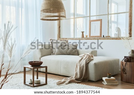 Stylish interior of living room with design modular sofa, furniture, wooden coffee table, rattan decoration, mock up picture frame, pillow, dried flowers and elegant  accessories in modern home decor.