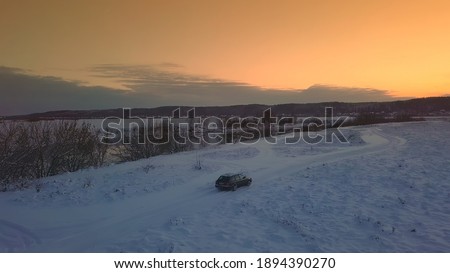 Winter. Sunset. bridge across the Dnieper. Belarus. Aerial photos from drone of river against background of forest and bridge, cars moving along it. Rural area. The sunset or sunrise, beautiful sun.