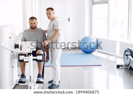 Patient has a rehabilitation in physiotherapy clinic. Doctor in a uniform. Royalty-Free Stock Photo #1894406875