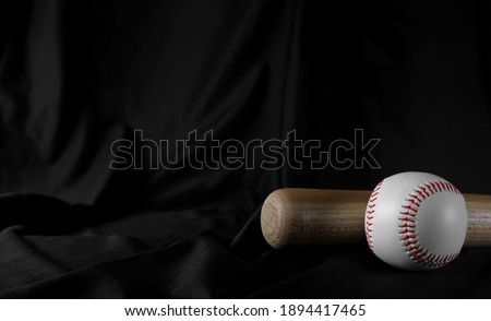 Baseball bat and ball on black drape background and texture, curtain backdrop 