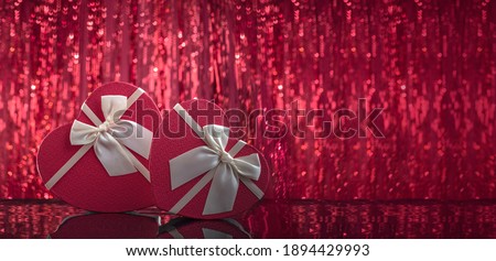 Heart shaped box lovers' gifts on mirror surface, red shining bokeh background. Valentine's day 14 february or romantic evening invitation,  postcard, poster, banner.