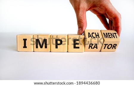 Imperator or impeachment symbol. Businessman hand turns wooden cubes and changes the word 'imperator' to 'impeachment'. Beautiful white background, copy space. Business, impeachment concept.