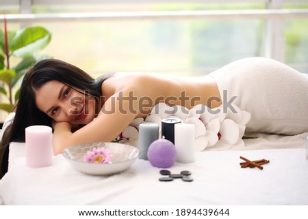 young woman lying on massage bed at spa and wellness center
