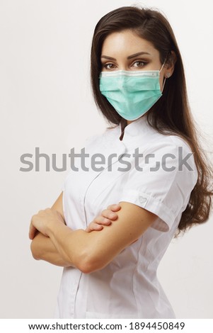 beautiful woman doctor folded arms wearing mask Royalty-Free Stock Photo #1894450849