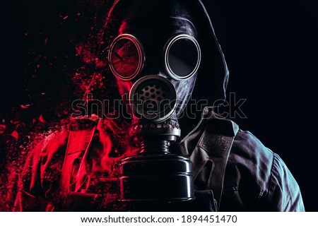 Photo of a stalker face in soviet old gas mask with filter and red highlights dissolving on black background. Royalty-Free Stock Photo #1894451470
