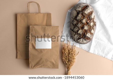 Craft paper blank shopping bags with bread, bakery branding mockup, empty space to display your logo or design.