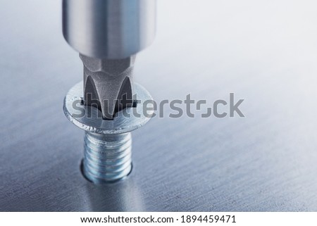 Screwdriver screw in metal steel plate bolt. Spanner, bolt, screw and nuts. Royalty-Free Stock Photo #1894459471