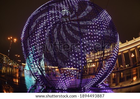 Details of Moscow city street decoration to New Year holidays. Festive mood concept. Fish eye lens. Decorative ball glowing with blue and purple lights