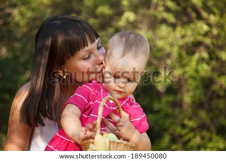 Young beautiful woman with her little 1 year old daughter having fun on the picnic