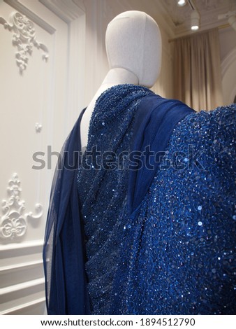 Stylish luxury dark blue evening dress with beads on a mannequin 