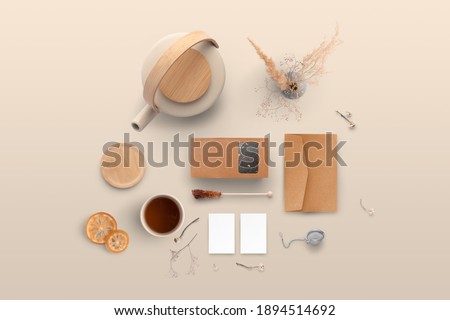 Blank tea packaging with a transparent window, pot, teacup, business cards, envelope, on a warm background, packaging mockup with empty space to display your branding design.