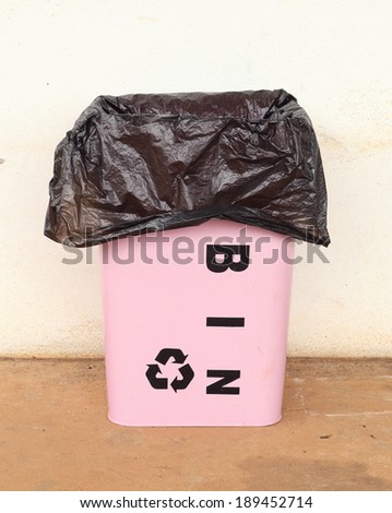 pink trash can with a plastic bag