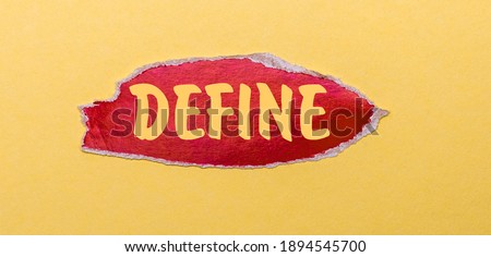 On a yellow background, a sheet of red paper with the word DEFINE.