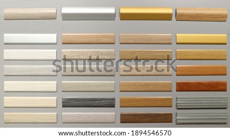 Wooden baseboards samples with different colors for different types of floor. Gray background. Royalty-Free Stock Photo #1894546570