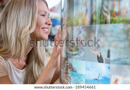 Woman selecting tv channel on glass touch screen