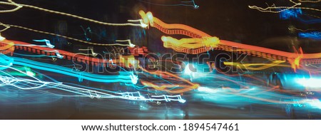 Long exposure photography. Defocused photography of Moscow cityscape in night time. Big traffic. Street is filled by cars. Blurred motion of cable car. Yellow, red, brown, black colors