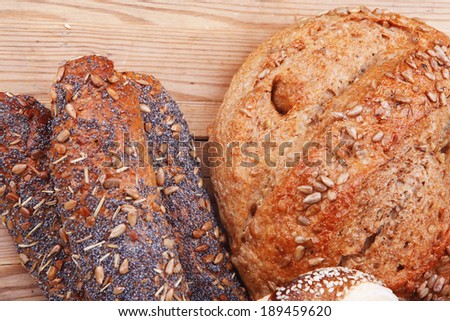 hot rural french round rye bread and baguette topped with sunflower seeds and sweet bagels on wooden tables
