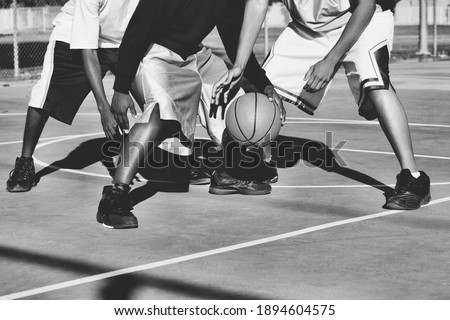 Black and white photo of teenagers playing basketball
