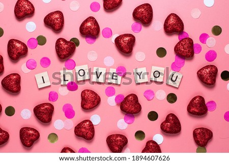 card for valentine's day. on a pink background wooden letters lined with I love you. funny congratulations. Flat lay, top view