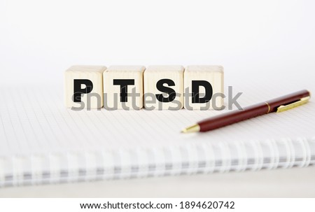 PTSD. written word. cubes, notepad and pen.. You can use in business, marketing and other concepts. Messege of the day.