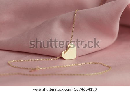 Gold jewelry on a pink background. Gift for Valentine's Day. Pleasure girlfriends, women, wives. Preparing for Valentine's Day. Pure pink background, fabric. earrings, ring, diamonds, chain Royalty-Free Stock Photo #1894654198