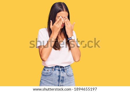 Young hispanic woman wearing casual white tshirt rubbing eyes for fatigue and headache, sleepy and tired expression. vision problem 
