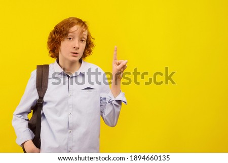 Empty space for text. Yellow background. A teenage boy holds his index finger up.