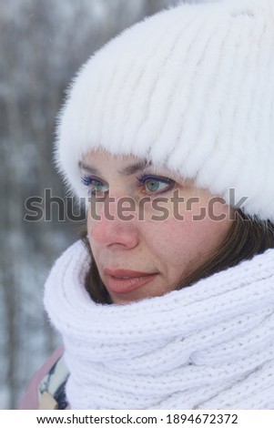 Portrait of a girl in winter clothes. In the winter park. Face close-up.
