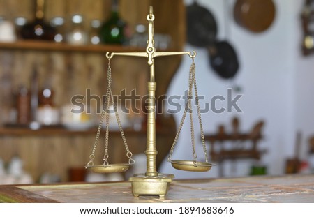 a small brass beam scale on a table Royalty-Free Stock Photo #1894683646