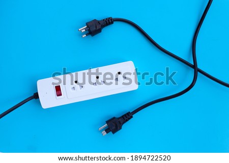Electrical power strip and plugs on blue background. Top view