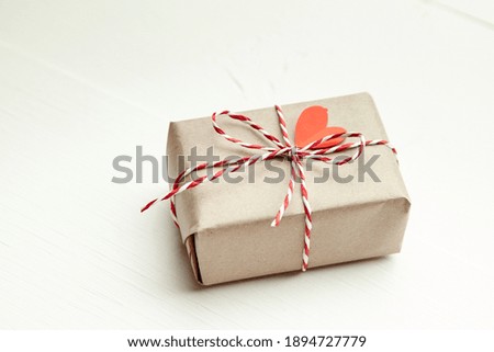 Valentines day gift box decorated with red heart on white table