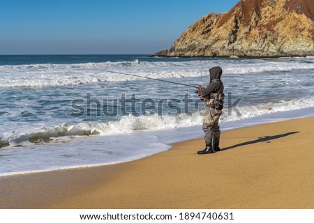 A fisherman is fishing on the Pacific coast.