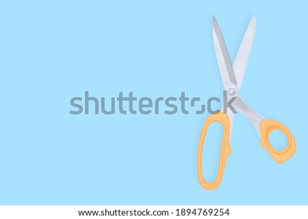 Barber scissors against blue background backdrop