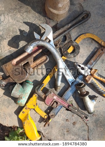 Vintage rusty metal iron pipe wrench, screw wrench, Pliers and hand hacksaw isolated on ground background. Plumbing tools, plumbing equipment