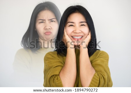 Asian woman having double personality ,mood swings or bipolar disorder with different emotions moody, happy face  Royalty-Free Stock Photo #1894790272