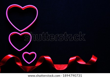 
box of red and pink hearts chocolates on black background with red ribbon, Valentine's Day, advertising banner