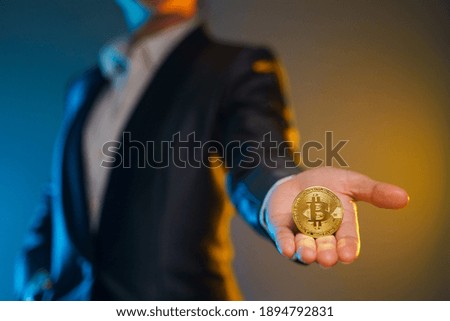 Close up shot of Business woman in black suit holding golden coin isolated on background.